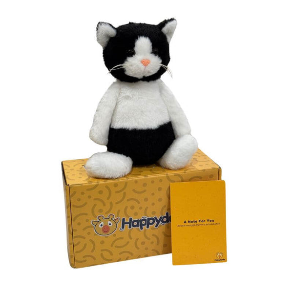 Shade the Cat black and white plush sitting on a Happydandis gift box with a handwritten keepsake card